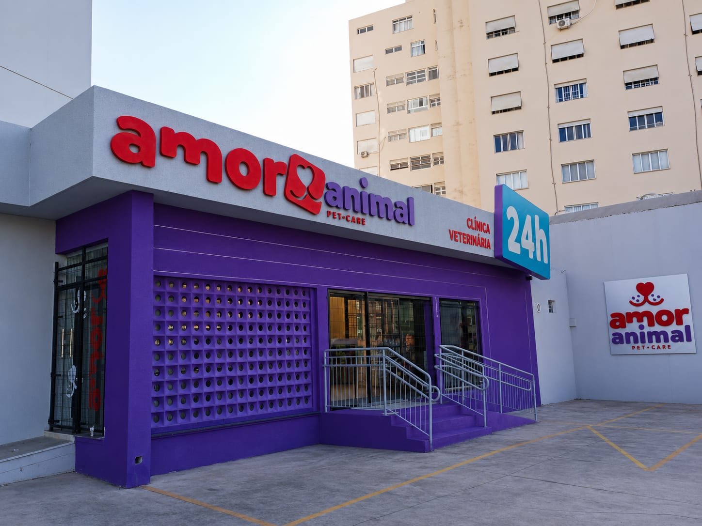 Fachada da Amor Animal Pet Care, com o letreiro vermelho e o selo azul Clínica Veterinária 24h