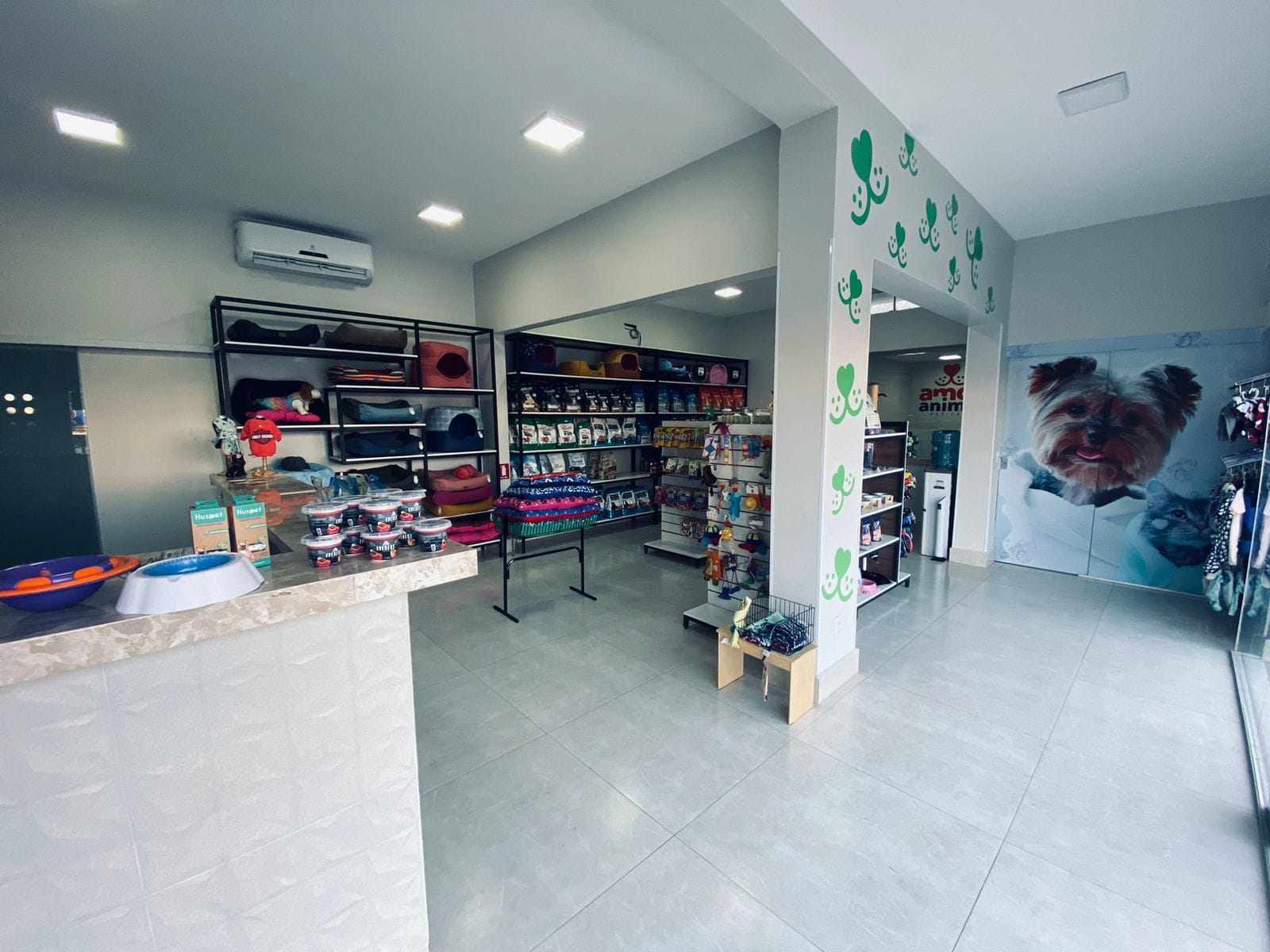 Interior da loja Amor Animal Pet Care, moderna e climatizada, com prateleiras de produtos